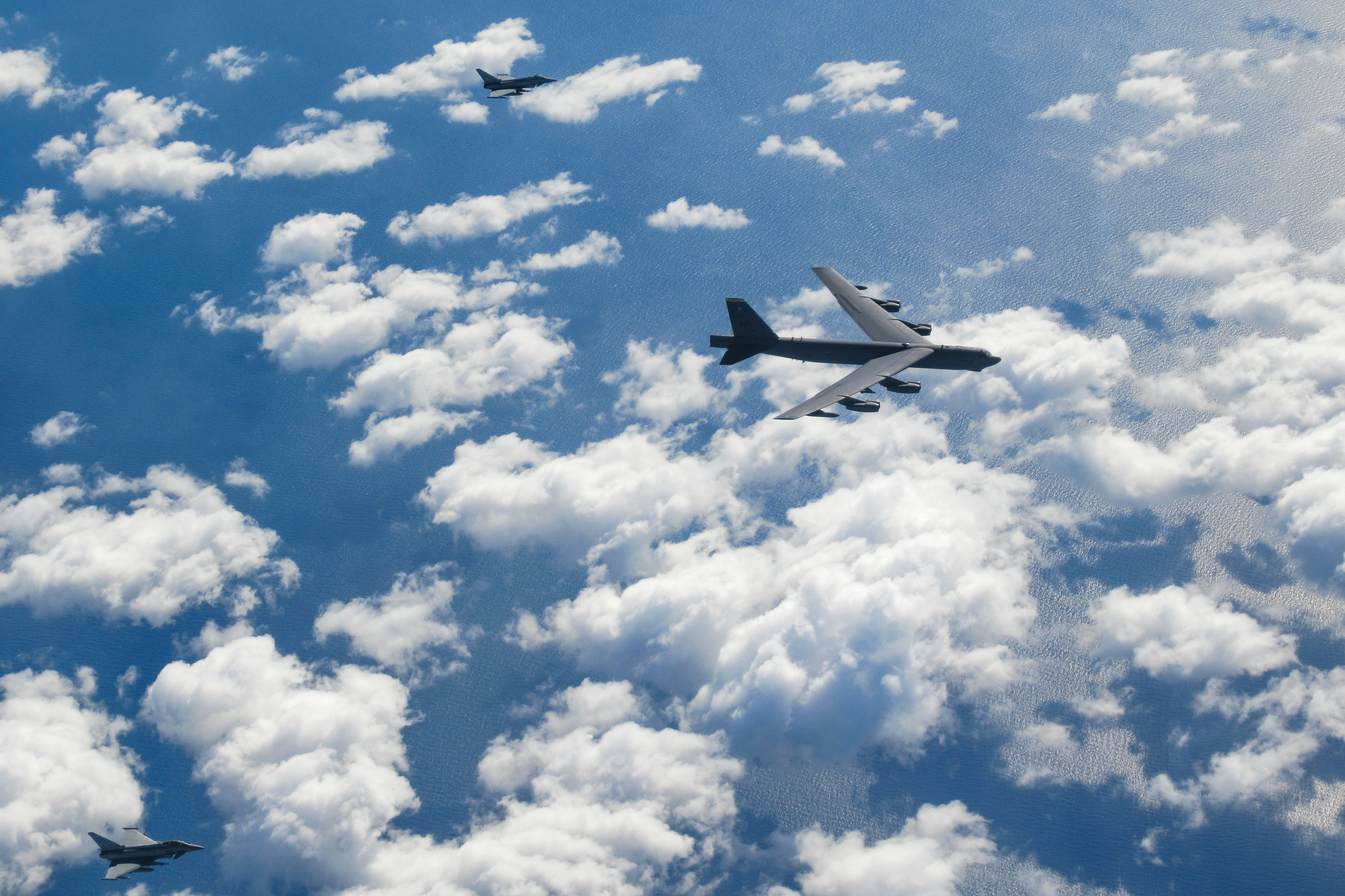 United States Air Force B-52 bomber and two RAF Typhoons above the clouds.